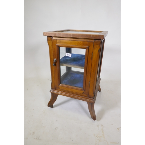 1087 - A small walnut vitrine with single door, raised on shaped supports with castors, 39 x 39 x 66cm