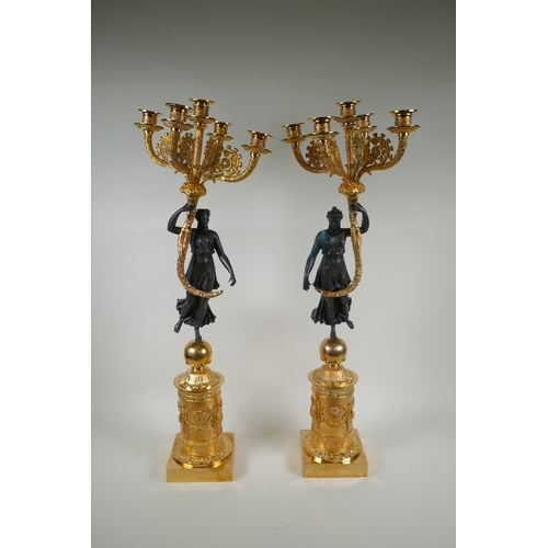 109 - A pair of Regency style bronze and ormolu four branch candelabra in the form of classical women hold... 