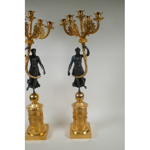 109 - A pair of Regency style bronze and ormolu four branch candelabra in the form of classical women hold... 