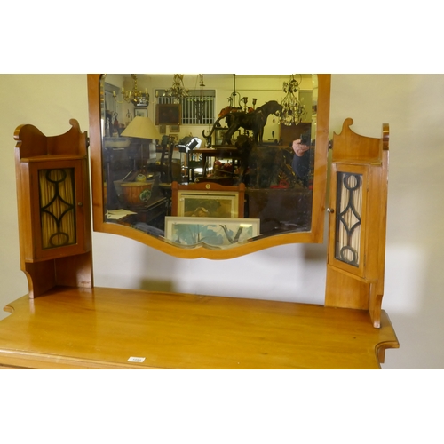 1090 - A Victorian satinwood dressing table, the upper section with mirror flanked by glazed cabinets, the ... 