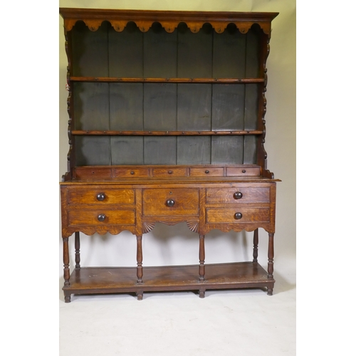 1092 - A Georgian oak potboard dresser, the upper section with enclosed delft rack under a shaped frieze, t... 