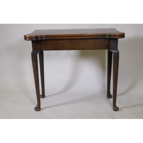 1094 - A Georgian mahogany fold over tea table with inlaid games top, shaped top and frieze drawer, raised ... 