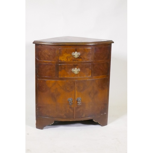 1095 - A bow fronted walnut corner cabinet, with two drawers over two cupboards, raised on bracket supports... 