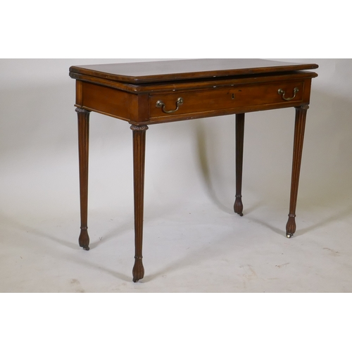 1097 - A Georgian mahogany fold over tea table, with single drawer and swan neck handles, raised on fluted ... 