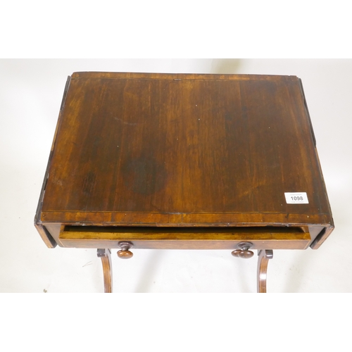 1098 - A Georgian rosewood work table with drop flaps and two drawers, raised on shaped end supports united... 