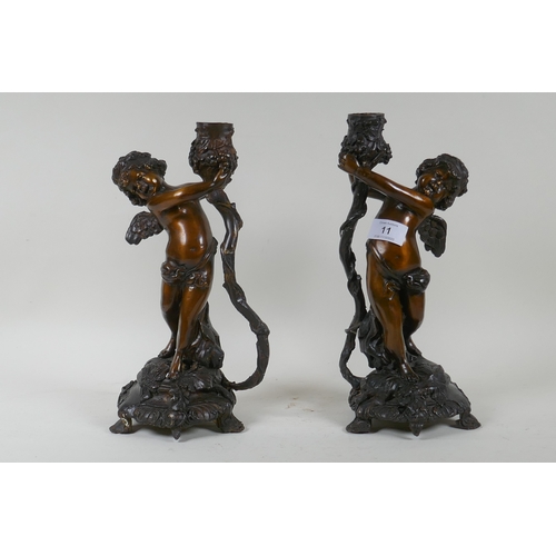 11 - A pair of bronze cherub candlesticks/lamp bases, 30cm high