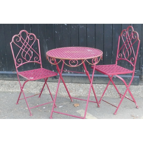 1105 - A painted iron bistro set of two folding chairs and a table, 62cm diameter