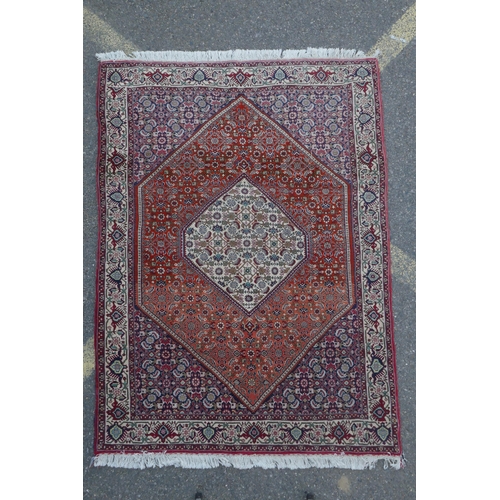 1126 - A red ground Persian Tabriz rug with multicolour allover design and cream borders, 118 x 162cm