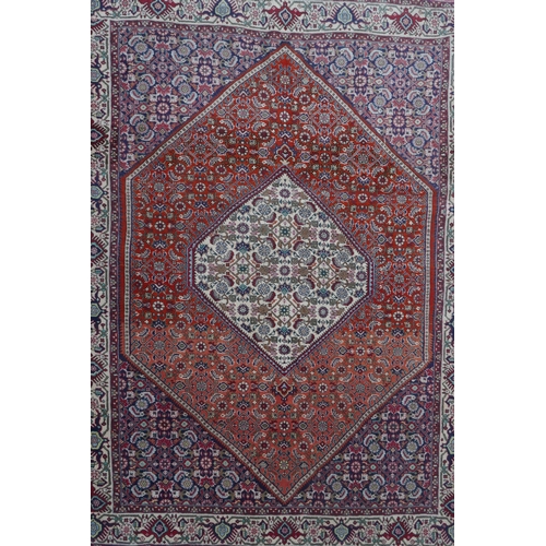 1126 - A red ground Persian Tabriz rug with multicolour allover design and cream borders, 118 x 162cm