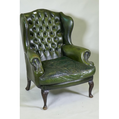 1147 - A green leather buttoned wingback armchair