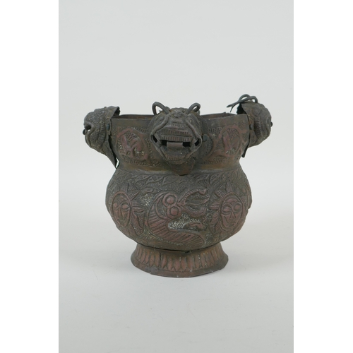 116 - A Nepalese copper pot decorated with four tiger masks and repousse decoration of snakes and suns, 15... 