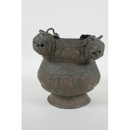 116 - A Nepalese copper pot decorated with four tiger masks and repousse decoration of snakes and suns, 15... 