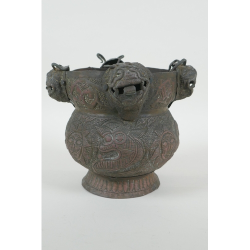 116 - A Nepalese copper pot decorated with four tiger masks and repousse decoration of snakes and suns, 15... 