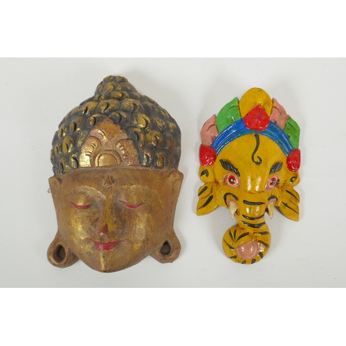 118 - An Indian carved and painted wood Ganesh wall mask and another carved and gilt Buddha mask, largest ... 