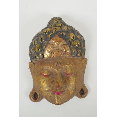 118 - An Indian carved and painted wood Ganesh wall mask and another carved and gilt Buddha mask, largest ... 