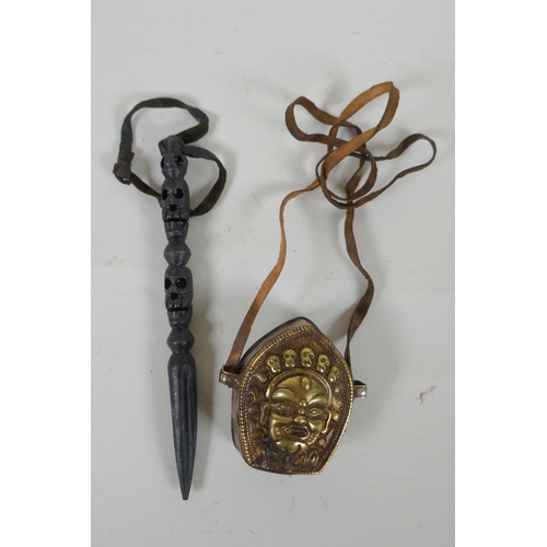 132 - A Tibetan cast metal phurba with skull shaped decoration to handle, together with a brass and copper... 