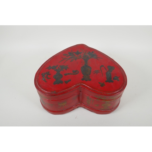 135 - A Chinese red lacquered heart shaped box decorated with objects of virtue in gilt, 32 x 26cm