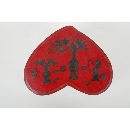 135 - A Chinese red lacquered heart shaped box decorated with objects of virtue in gilt, 32 x 26cm