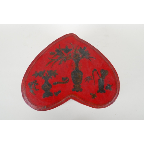 135 - A Chinese red lacquered heart shaped box decorated with objects of virtue in gilt, 32 x 26cm