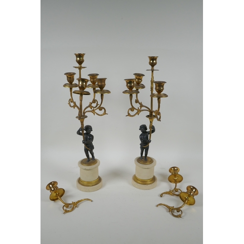 143 - A pair of ormolu and bronze Regency style five branch candlesticks in the form of putti, 44cm high, ... 