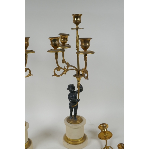 143 - A pair of ormolu and bronze Regency style five branch candlesticks in the form of putti, 44cm high, ... 