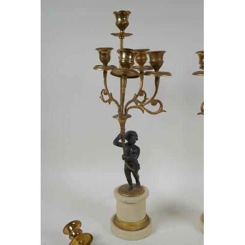 143 - A pair of ormolu and bronze Regency style five branch candlesticks in the form of putti, 44cm high, ... 