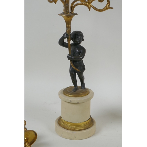 143 - A pair of ormolu and bronze Regency style five branch candlesticks in the form of putti, 44cm high, ... 