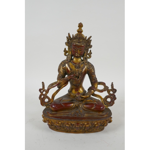 145 - A Tibetan gilt bronzed metal figure of Buddha holding a vajra, 21cm high