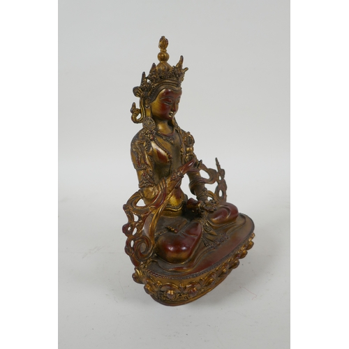 145 - A Tibetan gilt bronzed metal figure of Buddha holding a vajra, 21cm high