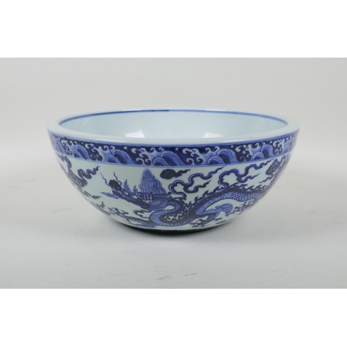 147 - A blue and white porcelain bowl decorated with two dragons, Chinese Xuande 6 character mark to bowl,... 