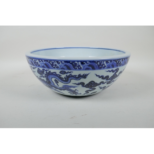 147 - A blue and white porcelain bowl decorated with two dragons, Chinese Xuande 6 character mark to bowl,... 