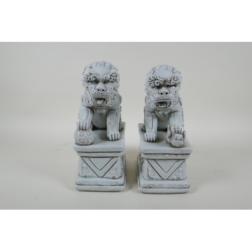 149 - A pair of Chinese blanc de chine porcelain temple lions, impressed marks to the reverse, 24cm high