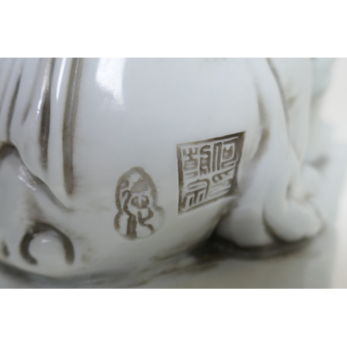 149 - A pair of Chinese blanc de chine porcelain temple lions, impressed marks to the reverse, 24cm high