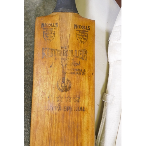 15 - A collection of vintage cricket equipment to include two Keith Miller autograph bats, a set of pads,... 