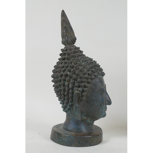 168 - A vintage bronze Buddha's head, mounted on a metal stand, 27cm high