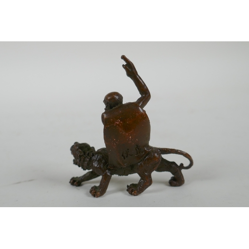 197 - A Chinese bronze figure of Lohan riding a tiger, 7cm long