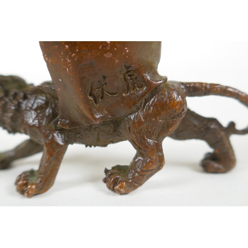 197 - A Chinese bronze figure of Lohan riding a tiger, 7cm long