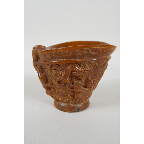 200 - A Chinese faux horn libation cup with carved kylin decoration, seal mark to base, 10cm high