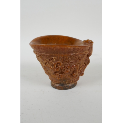 200 - A Chinese faux horn libation cup with carved kylin decoration, seal mark to base, 10cm high