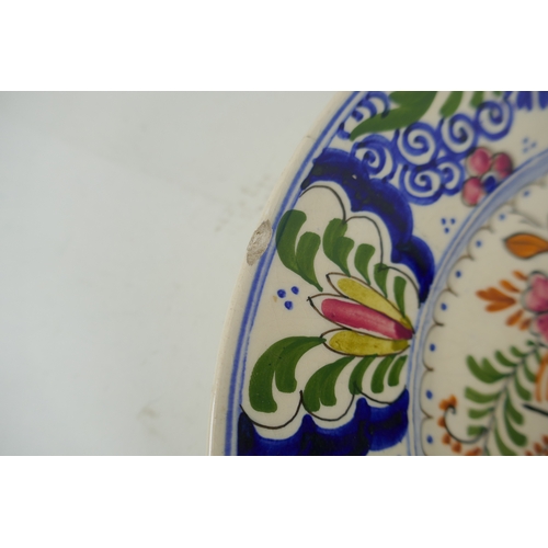 202 - A polychrome Delft cabinet dish with floral decoration, mark to bae, AF, 25cm diameter