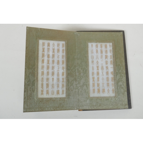 214 - A Chinese wood and silk bound book containing white jade table pages with chased and gilt inscriptio... 