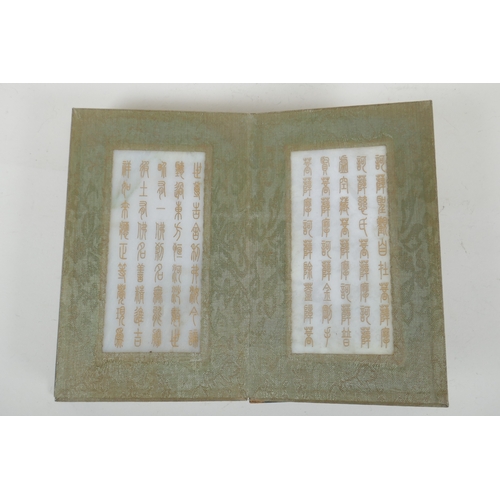 214 - A Chinese wood and silk bound book containing white jade table pages with chased and gilt inscriptio... 