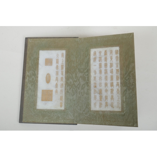 214 - A Chinese wood and silk bound book containing white jade table pages with chased and gilt inscriptio... 