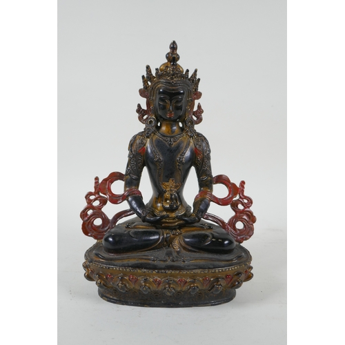 221 - A Tibetan lacquered and gilt bronze Buddha holding a stupa, 22cm high