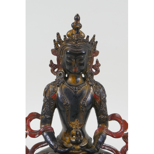 221 - A Tibetan lacquered and gilt bronze Buddha holding a stupa, 22cm high