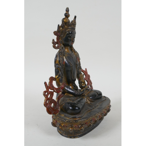 221 - A Tibetan lacquered and gilt bronze Buddha holding a stupa, 22cm high