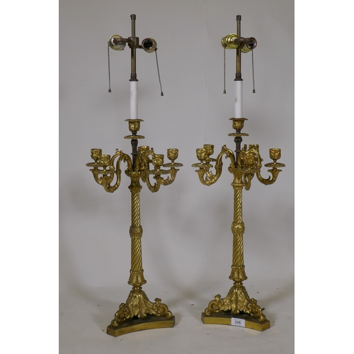 226 - A pair of ormolu five branch candelabra table lamps with twisted columns and scroll supports, 84cm h... 