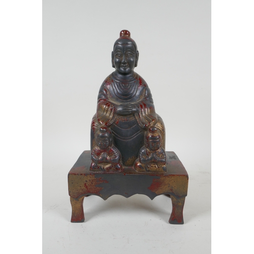 232 - A Chinese cast metal figure of an emperor seated on a throne, with the remnants of gilt patina, char... 