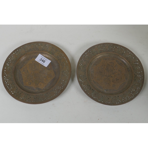 246 - A pair of Indian/Persian brass dishes with pierced rims and engraved decoration of men feasting and ... 