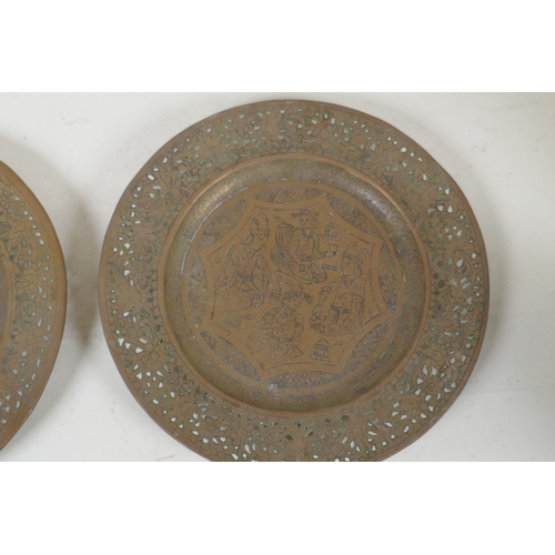 246 - A pair of Indian/Persian brass dishes with pierced rims and engraved decoration of men feasting and ... 